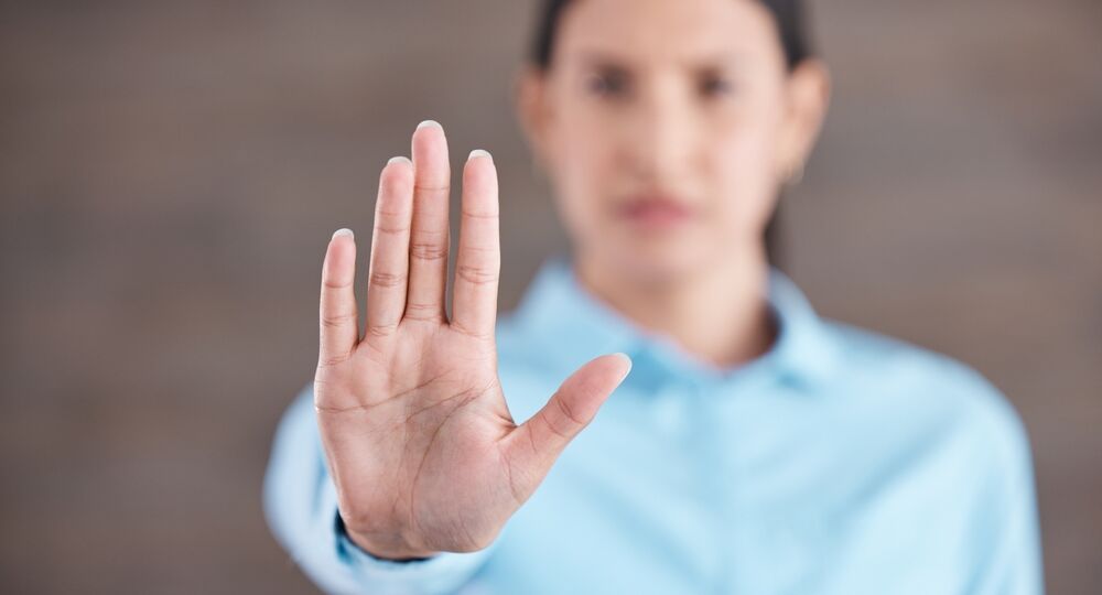 woman holding hand up to resist workplace discrimination