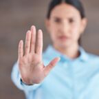 woman holding hand up to resist workplace discrimination