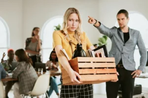 A woman holding a box with her belongings.