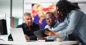 A group of people looking at a tablet.