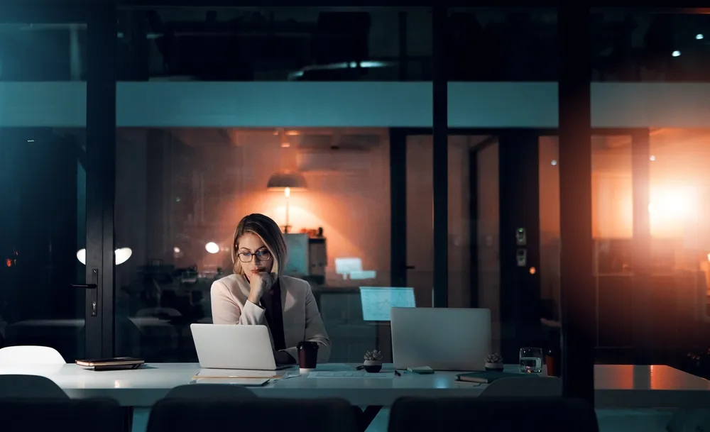 A woman sitting in front of her laptop late at night.