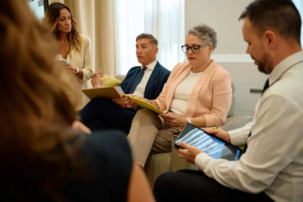 A group of people talking and reading together.