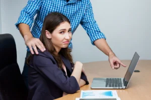 A man putting pressure on a woman at work