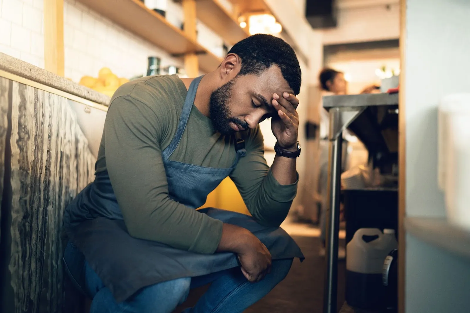 A man holding his head with his hand at the workplace