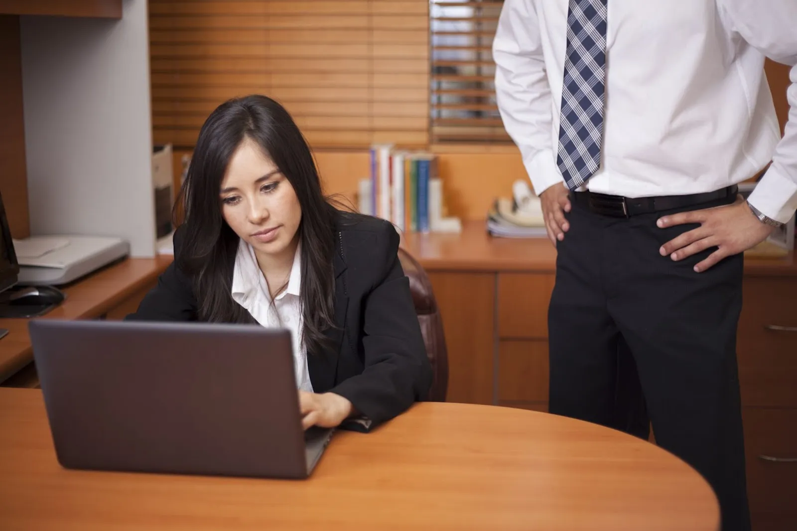 A man putting pressure on a woman at work